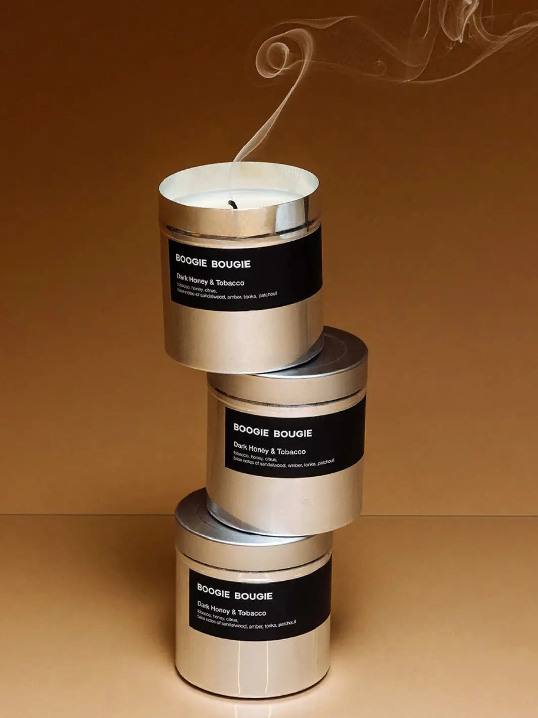 Stack of Dark Honey and Tobacco Boogie Bougie candles with smoke on a brown background | Twentyseven Toronto