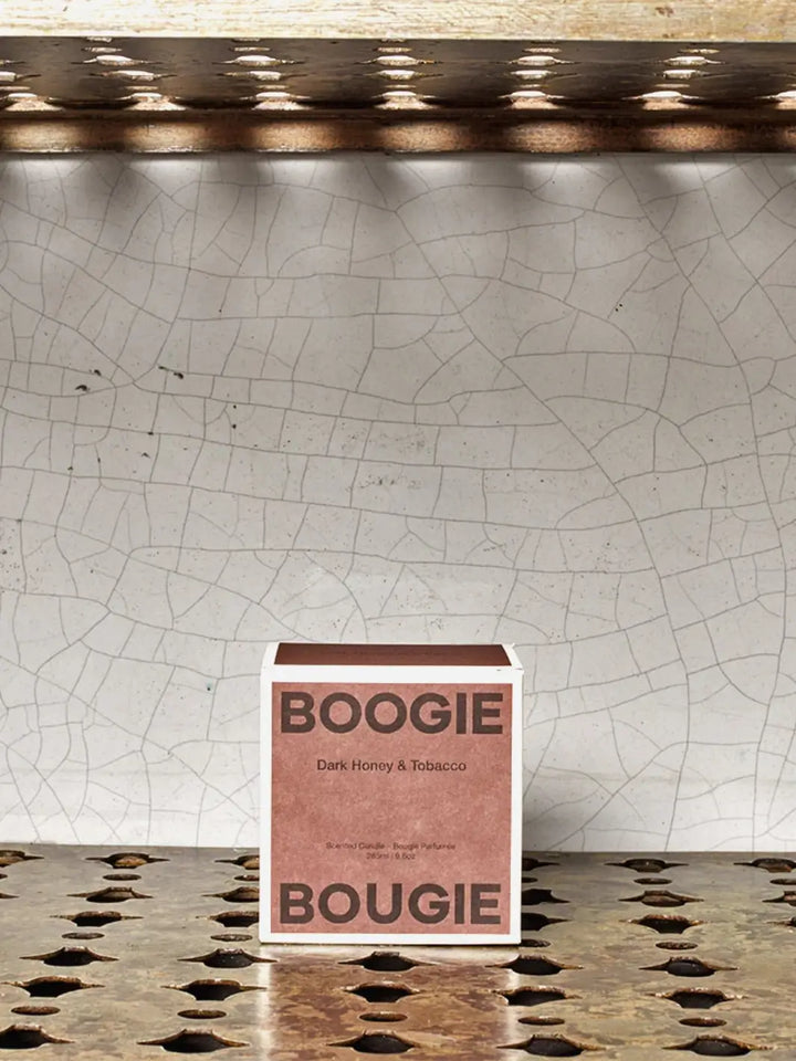 Brown Boogie Bougie Dark Honey and Tobacco product packaging on a textured surface with a cracked wall background | Twentyseven Toronto