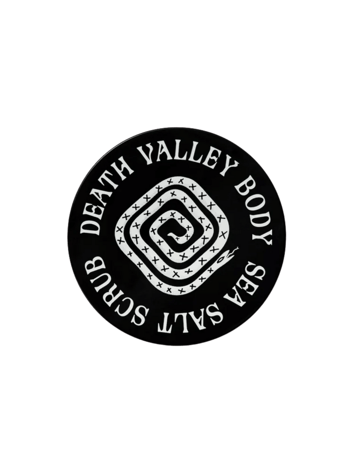 Black circular jar lid for Death Valley Nails Dead Sea Salt Scrub - Lemon + Sage + Peppermint + Earth, showcasing a white coiled snake illustration in the center | Twentyseven Toronto