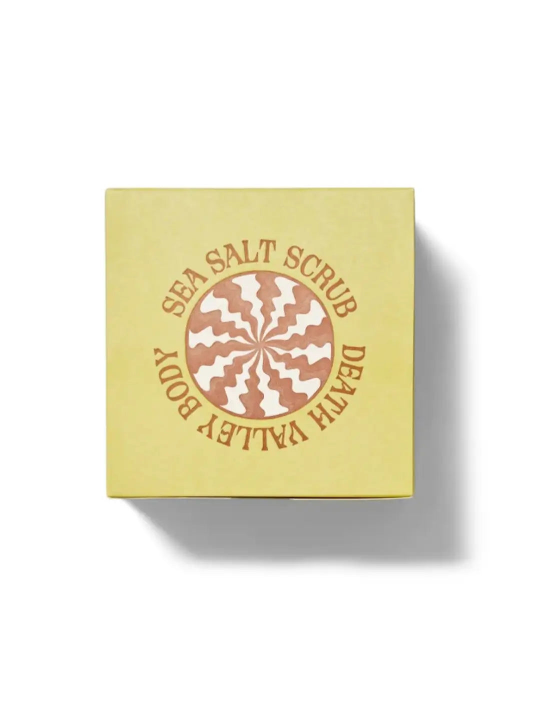 Top-down shot of the yellow packaging box for Death Valley Nails Dead Sea Salt Scrub - Lemon + Sage + Peppermint + Earth, featuring a central circular logo with a brown and white sunburst pattern | Twentyseven Toronto