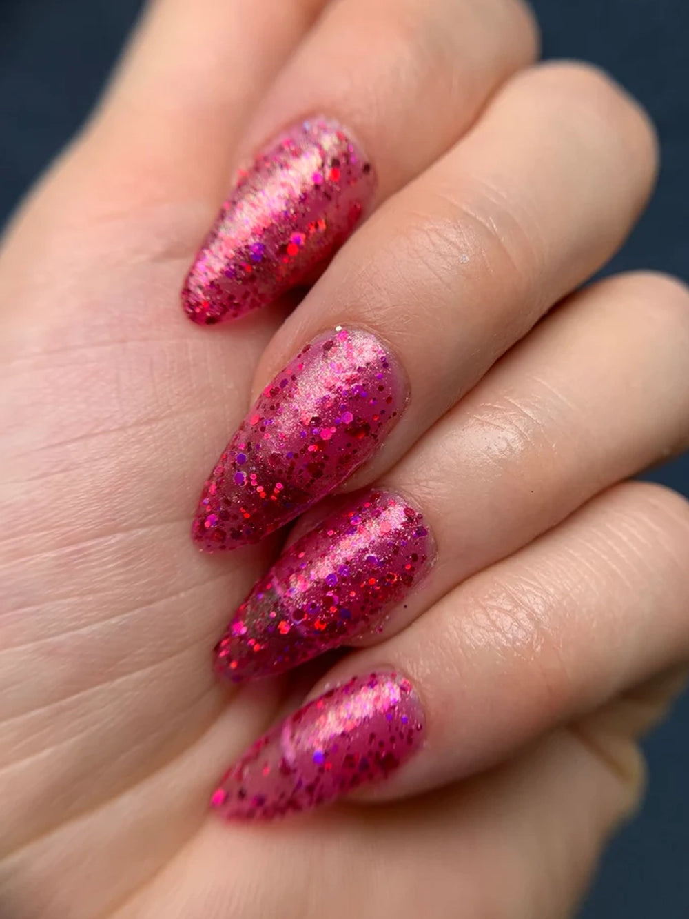 Close-up manicure featuring pink holographic glitter polish with a dimensional multichrome shimmer | Twentyseven Toronto