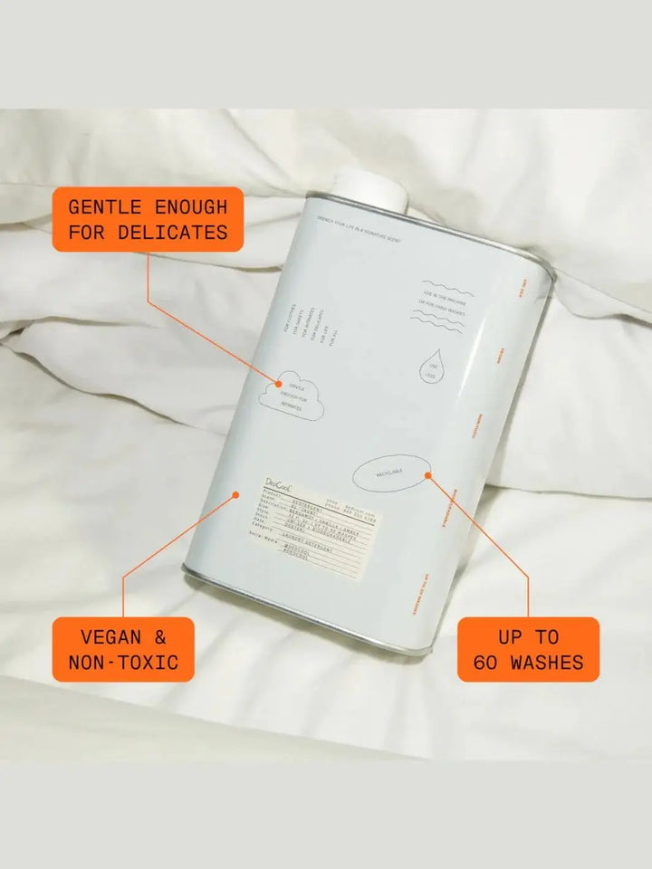 An aluminum tin of Dedcool Dedtergent Xtra Milk rests on white bedding surrounded by orange text bubbles highlighting its product benefits | Twentyseven Toronto