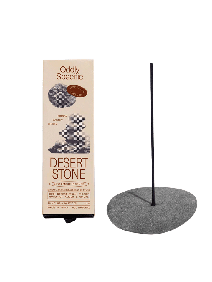 Oddly Specific Desert Stone Low Smoke Incense in beige packaging with stacked stone illustrations, displayed beside a dark incense stick in a grey stone holder | Twentyseven Toronto