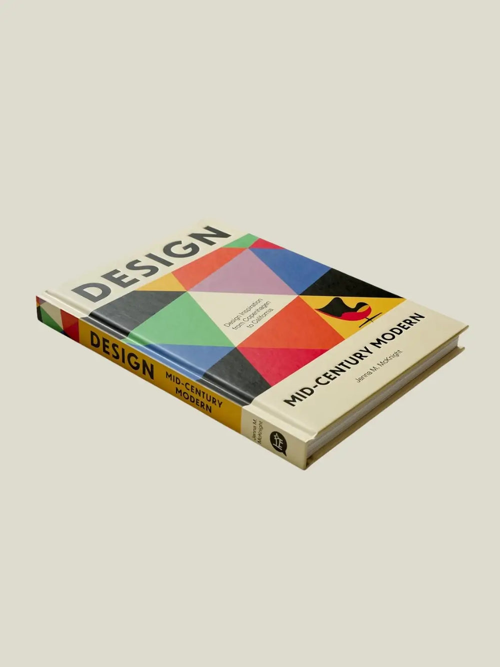 Hardcover book titled Design: Mid-Century Modern by Jenna M. McKnight, lying at an angle to show the colourful geometric cover | Twentyseven Toronto