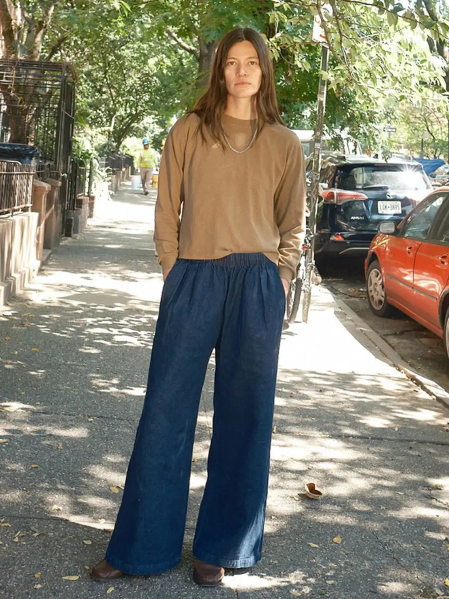 A model stands on a city sidewalk wearing a brown long-sleeve shirt paired with the wide-leg Jungmaven Disco Denim Pant - Dark | Twentyseven Toronto