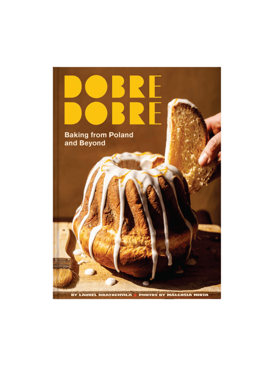 Front cover of the cookbook Dobre Dobre: Baking from Poland and Beyond by Laurel Kratochvila & Malgosia Minta, featuring a warm-toned photograph of a tall bundt cake | Twentyseven Toronto