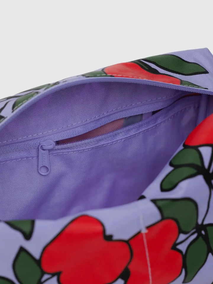 Close-up image shows the interior of the BAGGU Dopp Kit in Apple Tree, highlighting a purple zippered pocket and the exterior red apple pattern | Twentyseven Toronto