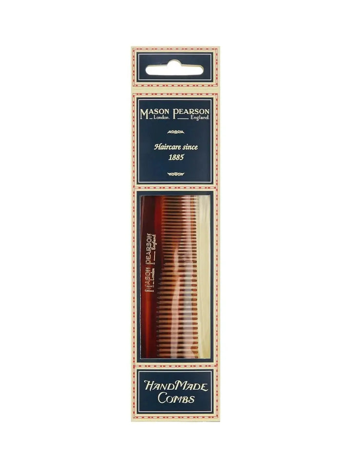 A premium tortoiseshell comb is shown inside its signature navy blue and cream retail cardboard packaging, introducing the product presentation of the Mason Pearson Dressing Comb C1 | Twentyseven Toronto