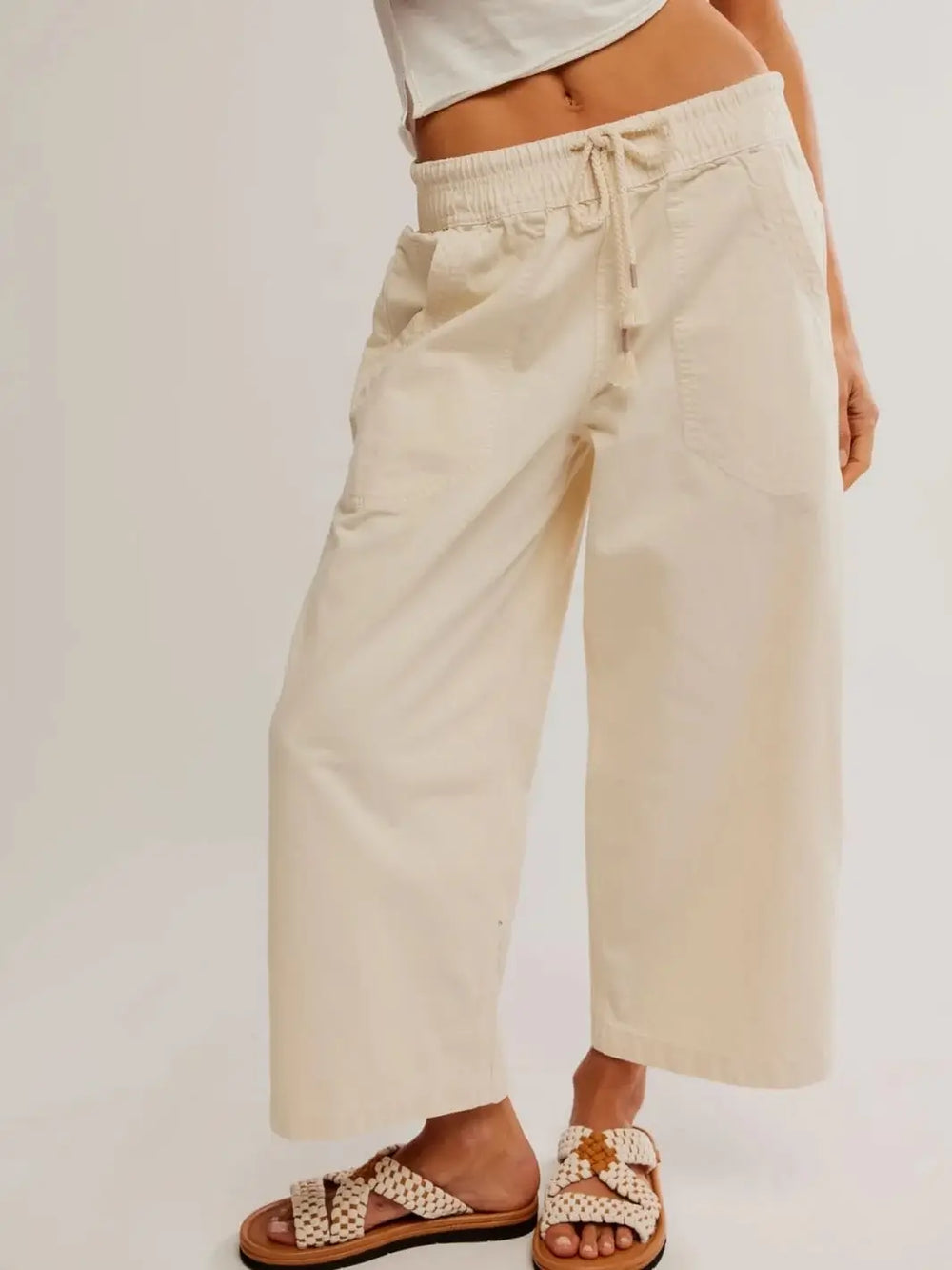 A low-angle front view highlights the wide-leg silhouette, deep front patch pockets, and woven slide sandals paired with the Free People Easy Peasy Pull-On Jeans in Irie | Twentyseven Toronto