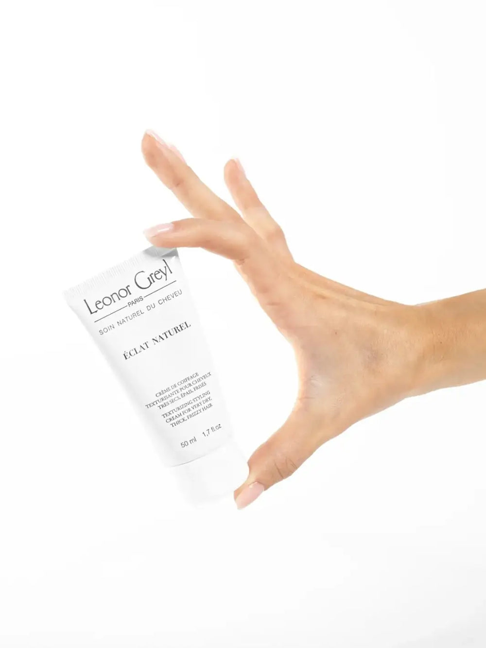 Hand holding a Leonor Greyl 'Éclat Naturel' tube against a white background | Twentyseven Toronto