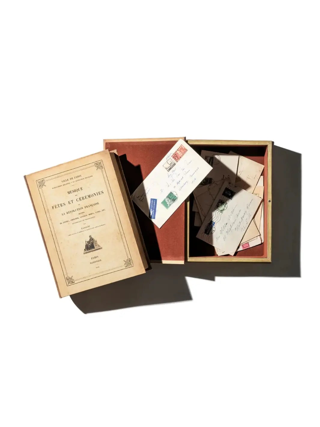 Open vintage book box, serving as a Decoration Tray / Oval from Puebco, filled with antique letters and postcards against a white background | Twentyseven Toronto