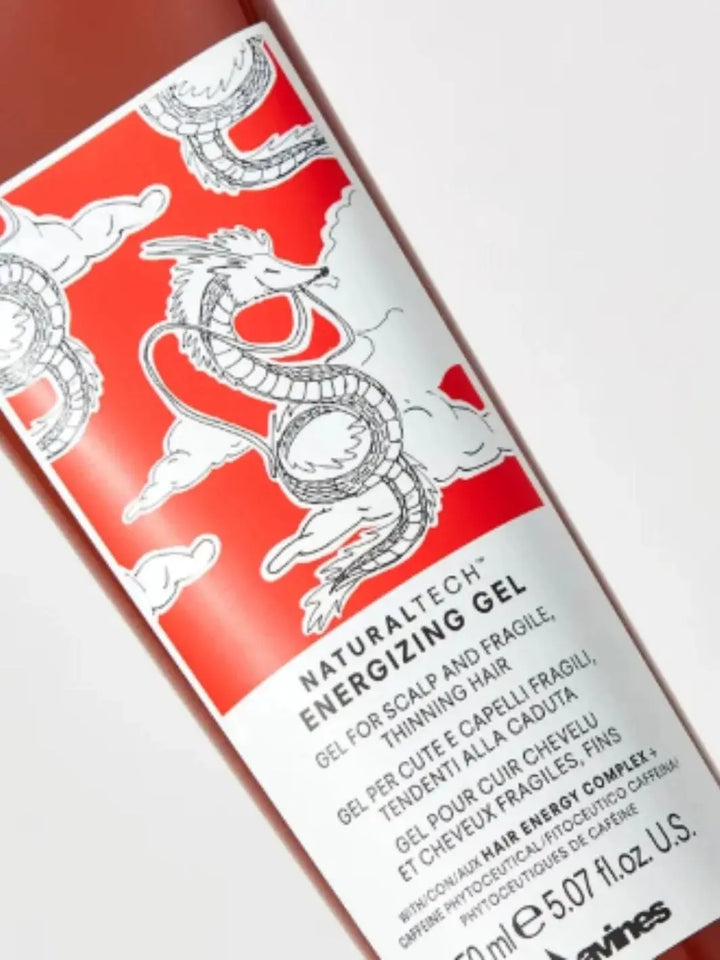 A close-up shot focuses on the white and red label of a Davines ENERGIZING Gel tube, featuring an illustration of a dragon amidst clouds | Twentyseven Toronto