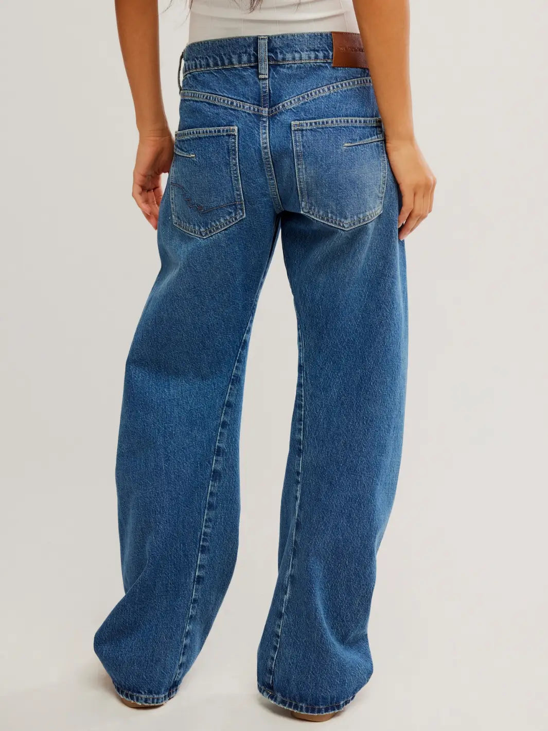 A rear view shows the classic five-pocket design, back yoke tailoring, and leather brand patch of the Free People Fable Twisted Seam Jean in Heartsong | Twentyseven Toronto