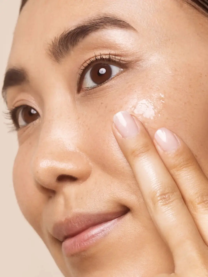 Close-up of a person applying Beauty from Bees Face Cleanser to their face with a neutral background | Twentyseven Toronto