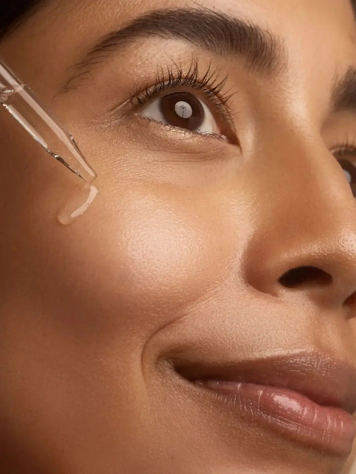 Close-up of a woman's face with a dropper applying Beauty from Bees Face Oil to her skin | Twentyseven Toronto