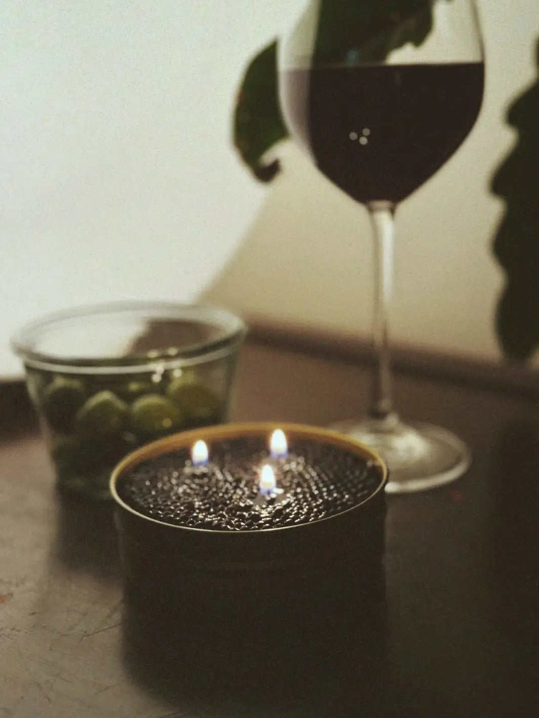 Lit Fancy Caviar Candle in gold tin from Tinned Fish Candle on a table | Twentyseven Toronto