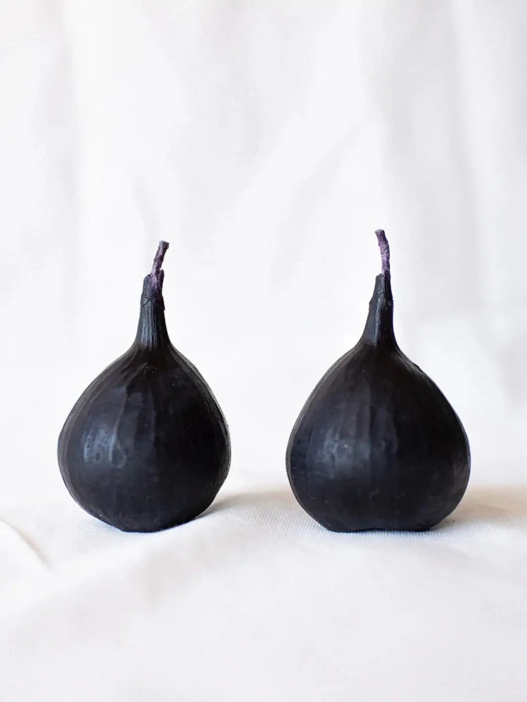 Two fig-shaped beeswax candles from Happy Organics on a white background | Twentyseven Toronto