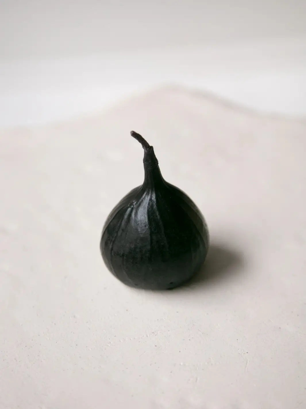 Fig-shaped beeswax candle from Happy Organics on a white background | Twentyseven Toronto