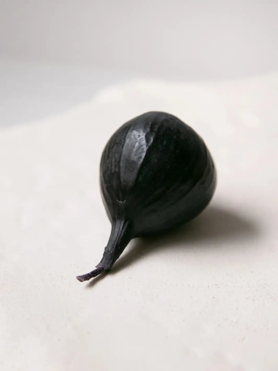 Fig-shaped beeswax candle from Happy Organics on a white background | Twentyseven Toronto