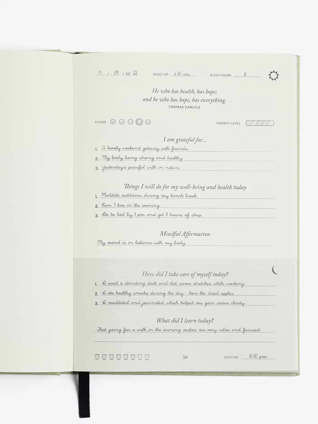 An open page of the Intelligent Change The Five Minute Journal Health & Fitness Edition displays completed handwritten daily entries for morning gratitude, daily wellness tasks, and evening reflection | Twentyseven Toronto