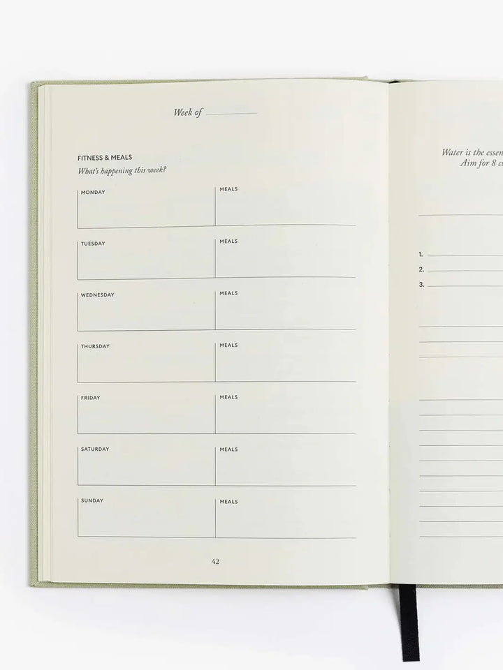 The weekly fitness and meals schedule page sits completely blank inside the open Intelligent Change The Five Minute Journal Health & Fitness Edition | Twentyseven Toronto