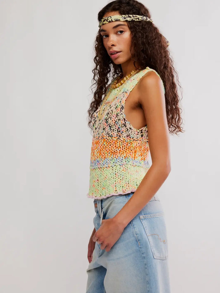 Woman wearing a colorful 'Flea Market Knot Tank' sleeveless top in 'Paradise Combo' and denim shorts from Free People on a white background, side view | Twentyseven Toronto