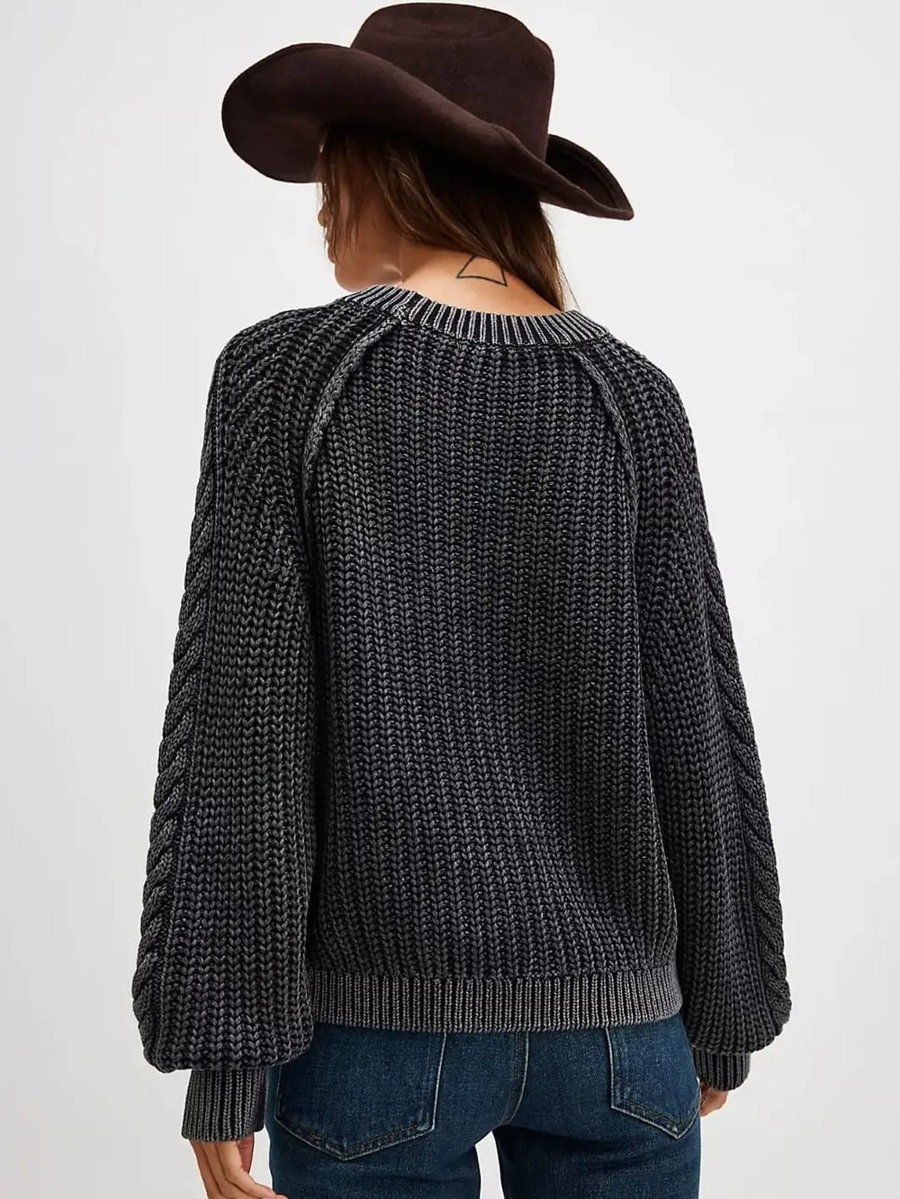 A direct rear view highlights the textured shaker knit pattern, raglan sleeve seams, and ribbed crew neckline of the Free People Frankie Cable Sweater in Black | Twentyseven Toronto
