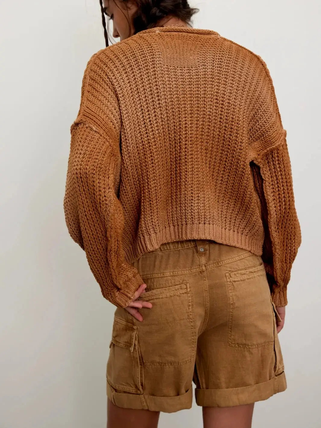 A rear view highlights the stitched back welt pockets and casual drape of the Free People Frankie Washed Shorts in Iced Coffee paired with a brown knit sweater | Twentyseven Toronto