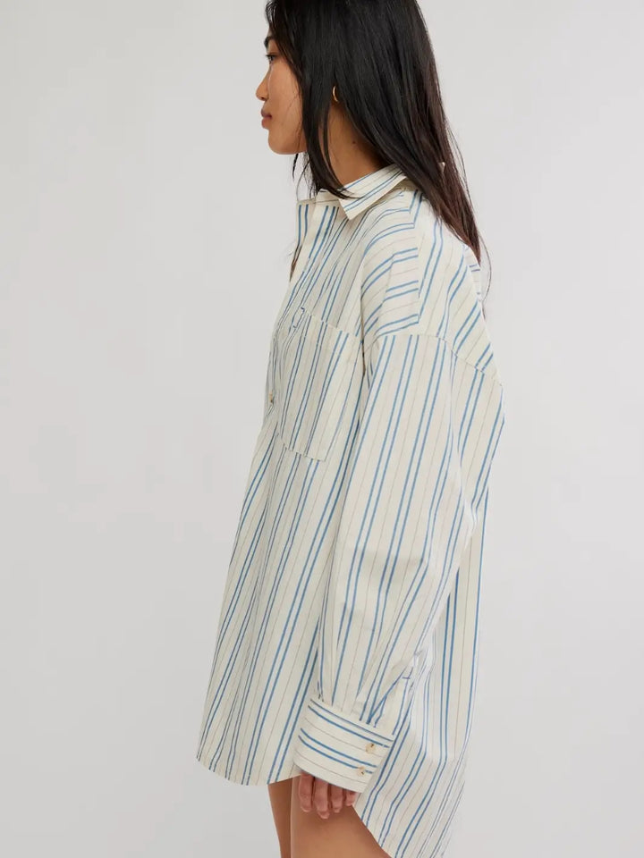 A side profile view highlights the slouchy fit, dropped shoulders, and buttoned cuffs of the Free People We the Free Freddie Striped Shirt in Ivory Combo | Twentyseven Toronto
