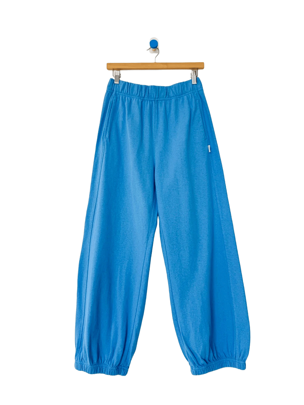 French Blue Balloon Pants displayed on a hanger, featuring a relaxed, voluminous silhouette, elastic waistband, side pockets and gathered ankle cuffs | Twentyseven Toronto