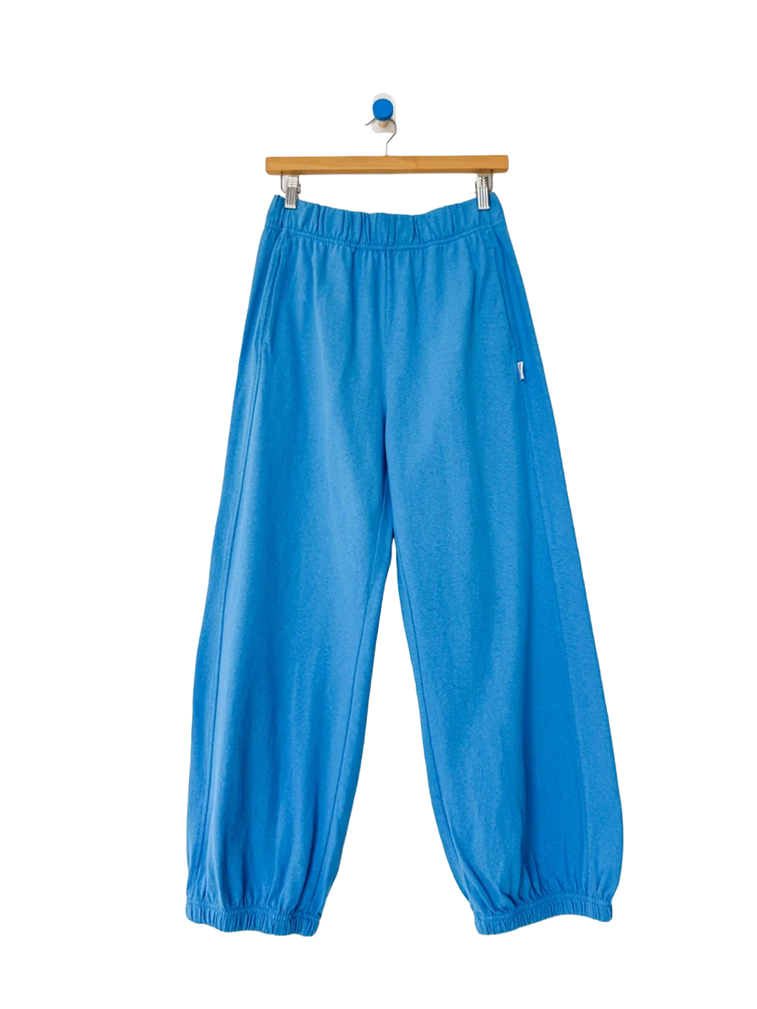 French Blue Balloon Pants displayed on a hanger, featuring a relaxed, voluminous silhouette, elastic waistband, side pockets and gathered ankle cuffs | Twentyseven Toronto