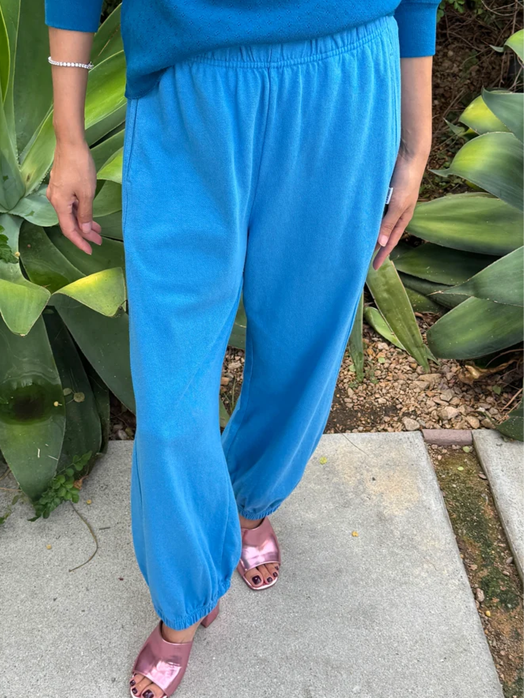 Front view of model wearing French Blue Balloon Pants with an elastic waistband, relaxed tapered legs and gathered ankle cuffs, styled with a matching blue sweater and metallic pink heels | Twentyseven Toronto