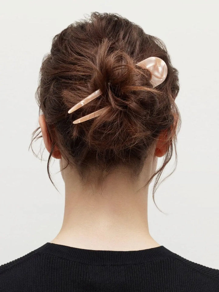 Back view of a person with a bun hairstyle using a French hair pin | Twentyseven Toronto