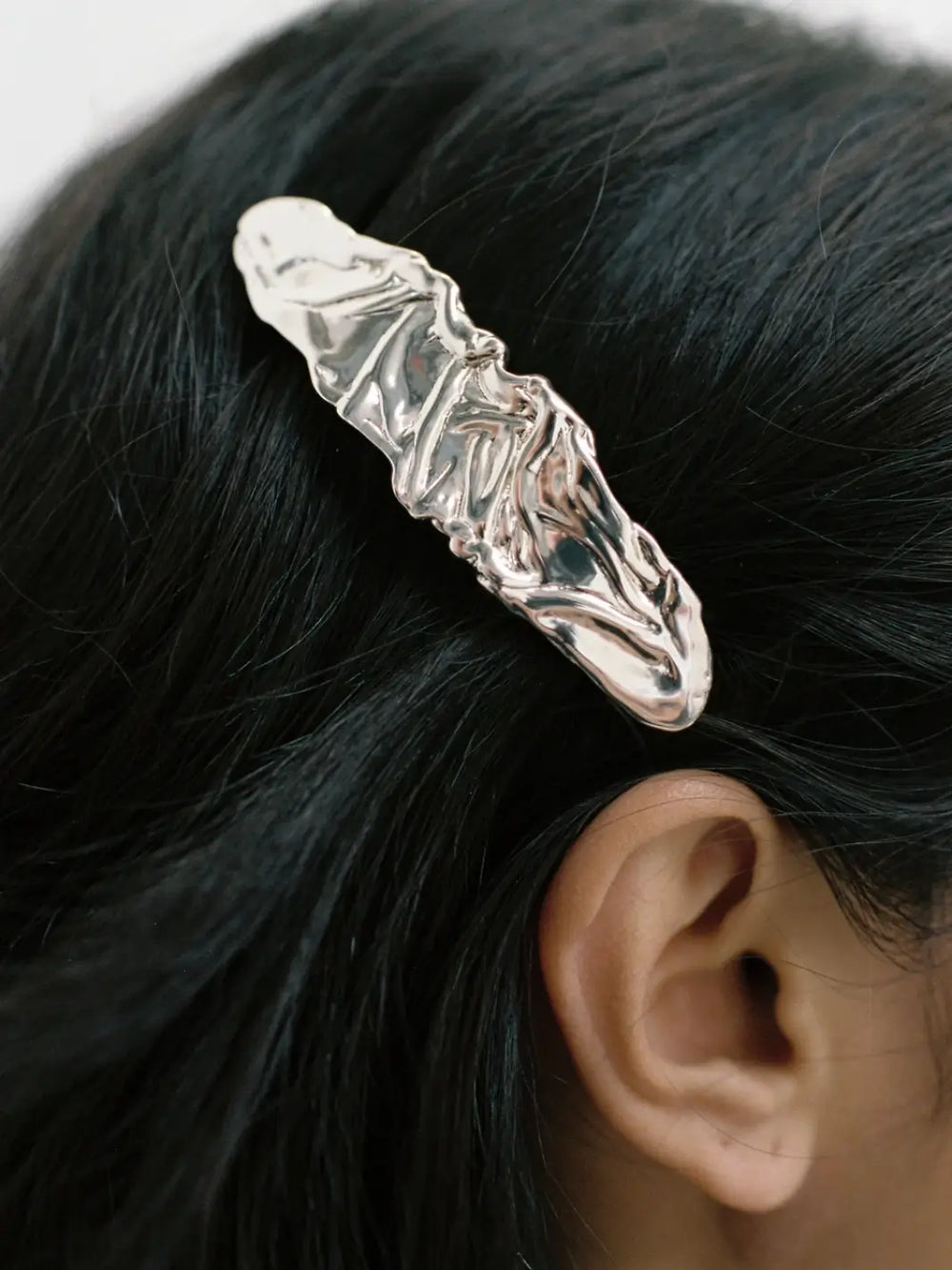 Textured, silver hair clip called the Frida Barrette in Silver from Wolf Circus pinned into a person's dark hair above the ear | Twentyseven Toronto