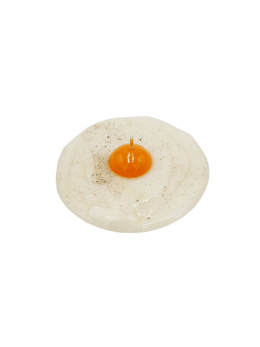 Fried egg shaped candle with pepper details from Cereria Introna on a transparent background | Twentyseven Toronto