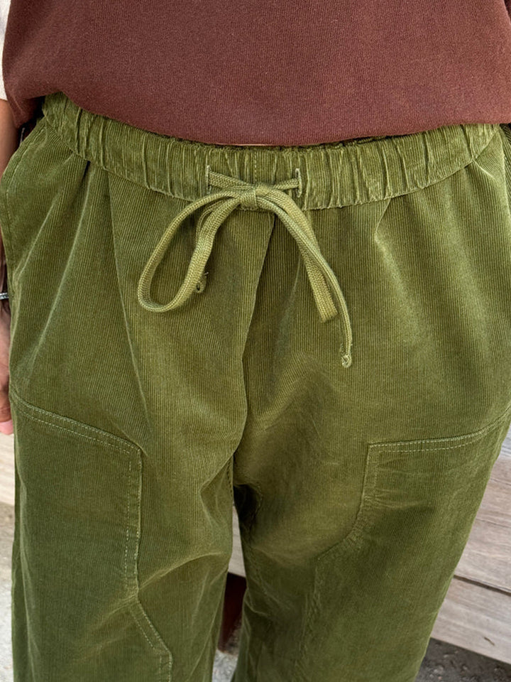 Close-up of Le Bon Shoppe Corduroy Gardener's Pants in Bay Leaf, showcasing the adjustable drawstring waistband, soft ribbed corduroy texture and front patch pockets | Twentyseven Toronto