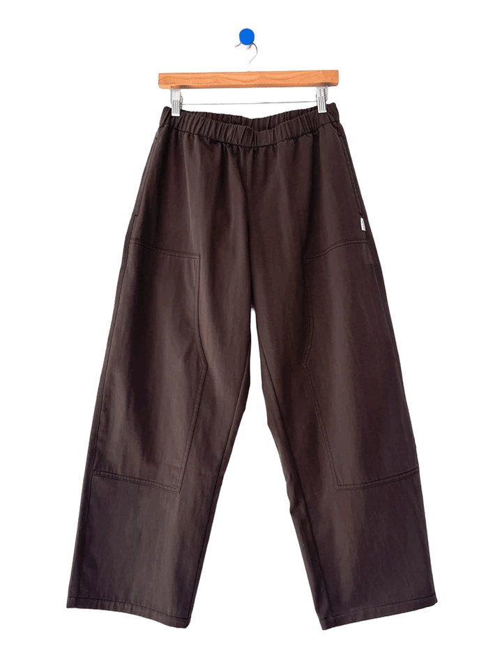 Le Bon Shoppe Gardener’s Pants in Espresso shown on a hanger, featuring a wide-leg silhouette, elastic waistband and oversized patch pockets | Twentyseven Toronto