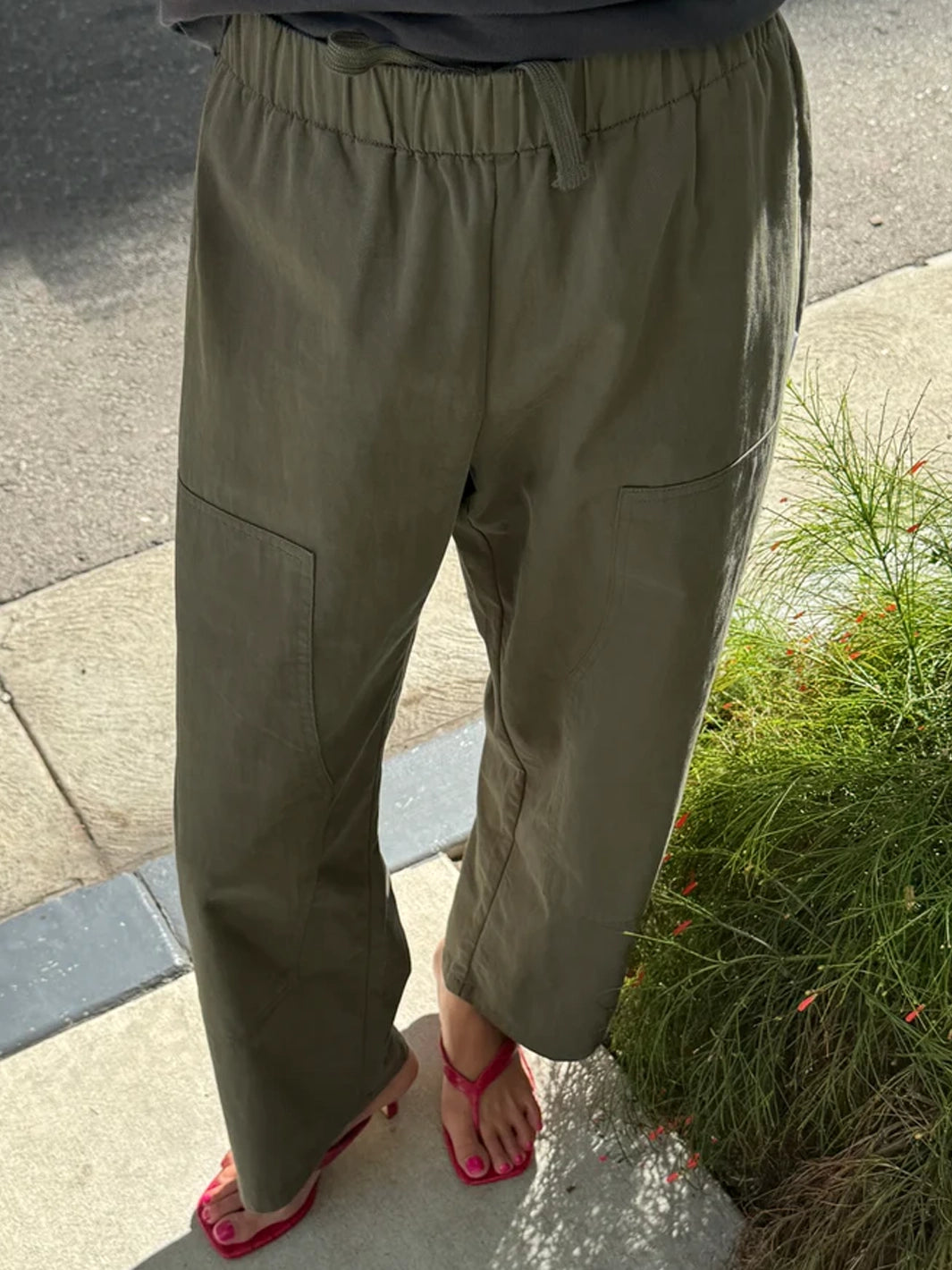 Gardener’s Pants in Army Green showing the relaxed tapered fit, elastic drawstring waist, and carpenter-inspired front patch pockets | Twentyseven Toronto
