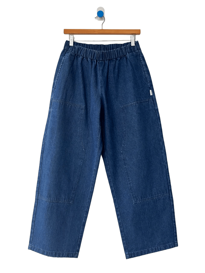Le Bon Shoppe Gardener’s Pants in Blue Denim featuring an elastic waistband, relaxed tapered leg, and carpenter-inspired front patch pockets | Twentyseven Toronto