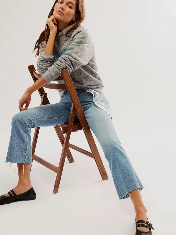 A model sits on a wooden chair wearing blue jeans and the black leather Free People Gemini Ballet Flats - Black | Twentyseven Toronto