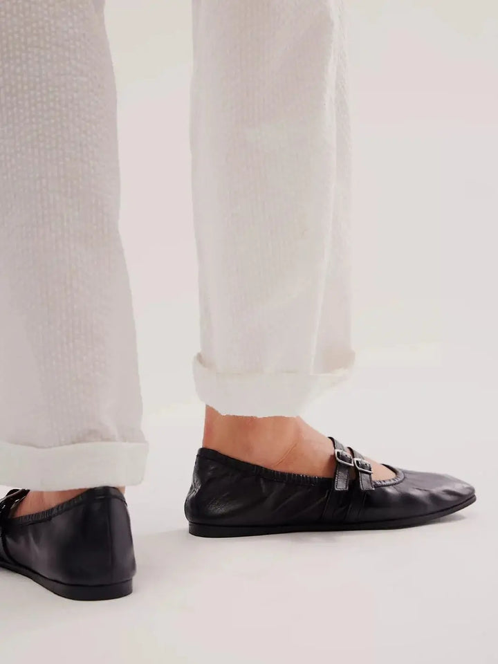 A side view showcases the flat profile and flexible leather construction of the Free People Gemini Ballet Flats - Black paired with white rolled-up pants | Twentyseven Toronto