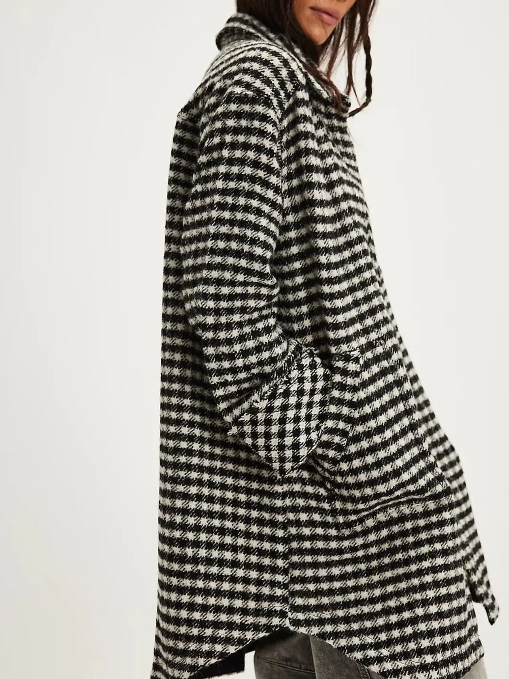 A side profile view highlights the curved hi-low hemline, relaxed drop-shoulder tailoring, and woven texture of the Free People Get Around Houndstooth Shirt - Black + White | Twentyseven Toronto