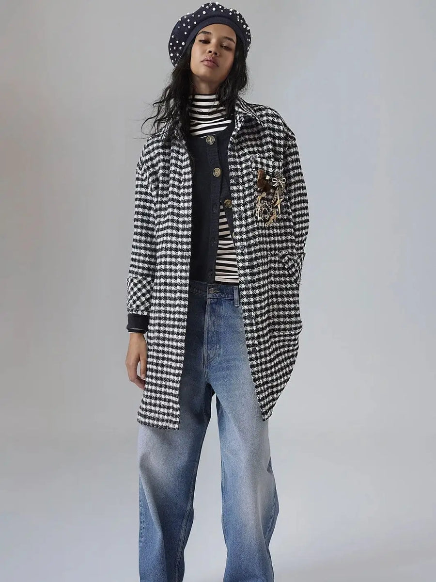 A full-length studio shot features a model wearing the longline Free People Get Around Houndstooth Shirt - Black + White layered with a striped turtleneck, cardigan, beret, and wide-leg jeans | Twentyseven Toronto