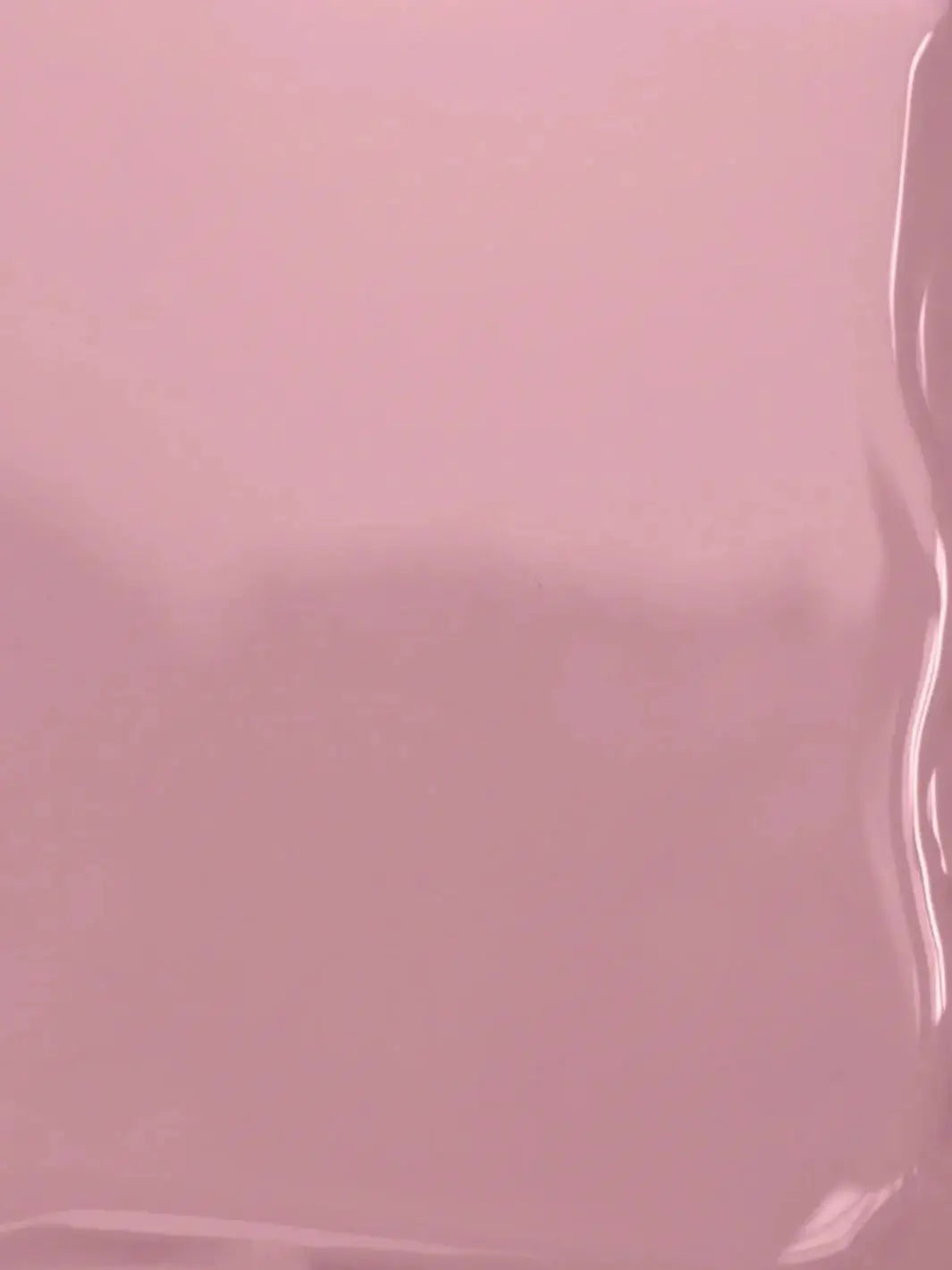 A close-up texture shot displaying the smooth, glossy, fluid surface of the mauve-pink BKIND Nail Polish in Wannabe formula | Twentyseven Toronto