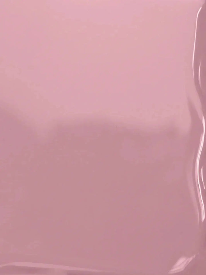 A close-up texture shot displaying the smooth, glossy, fluid surface of the mauve-pink BKIND Nail Polish in Wannabe formula | Twentyseven Toronto