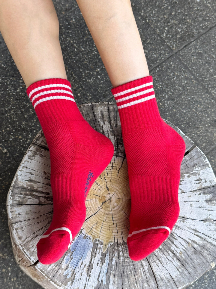 Le Bon Shoppe Girlfriend Socks in Scarlet with white contrast stripes, styled on a rustic wooden stool | Twentyseven Toronto