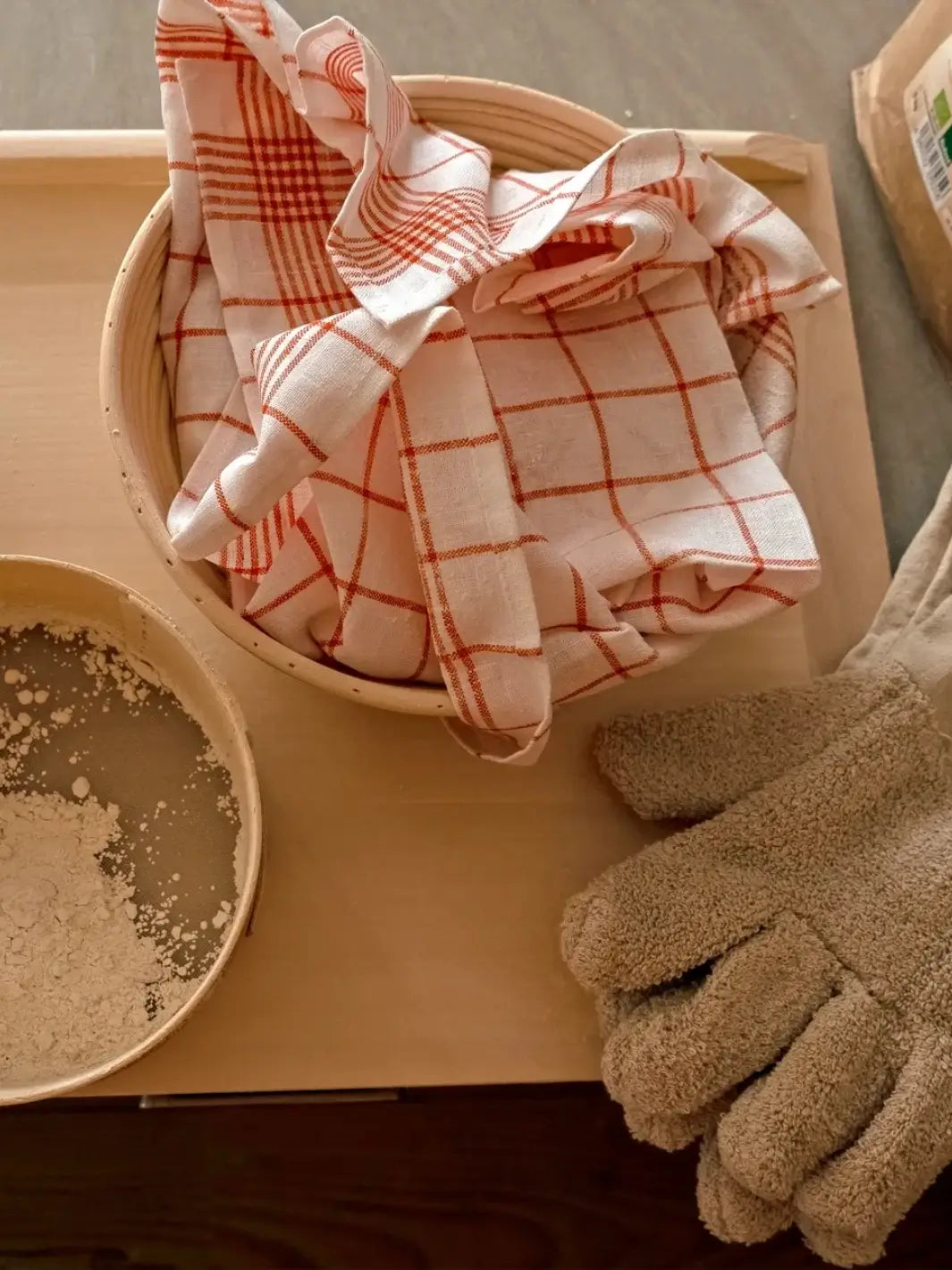Checkered red towel from Burstenhaus Redecker in a basket with gloves on a wooden surface | Twentyseven Toronto