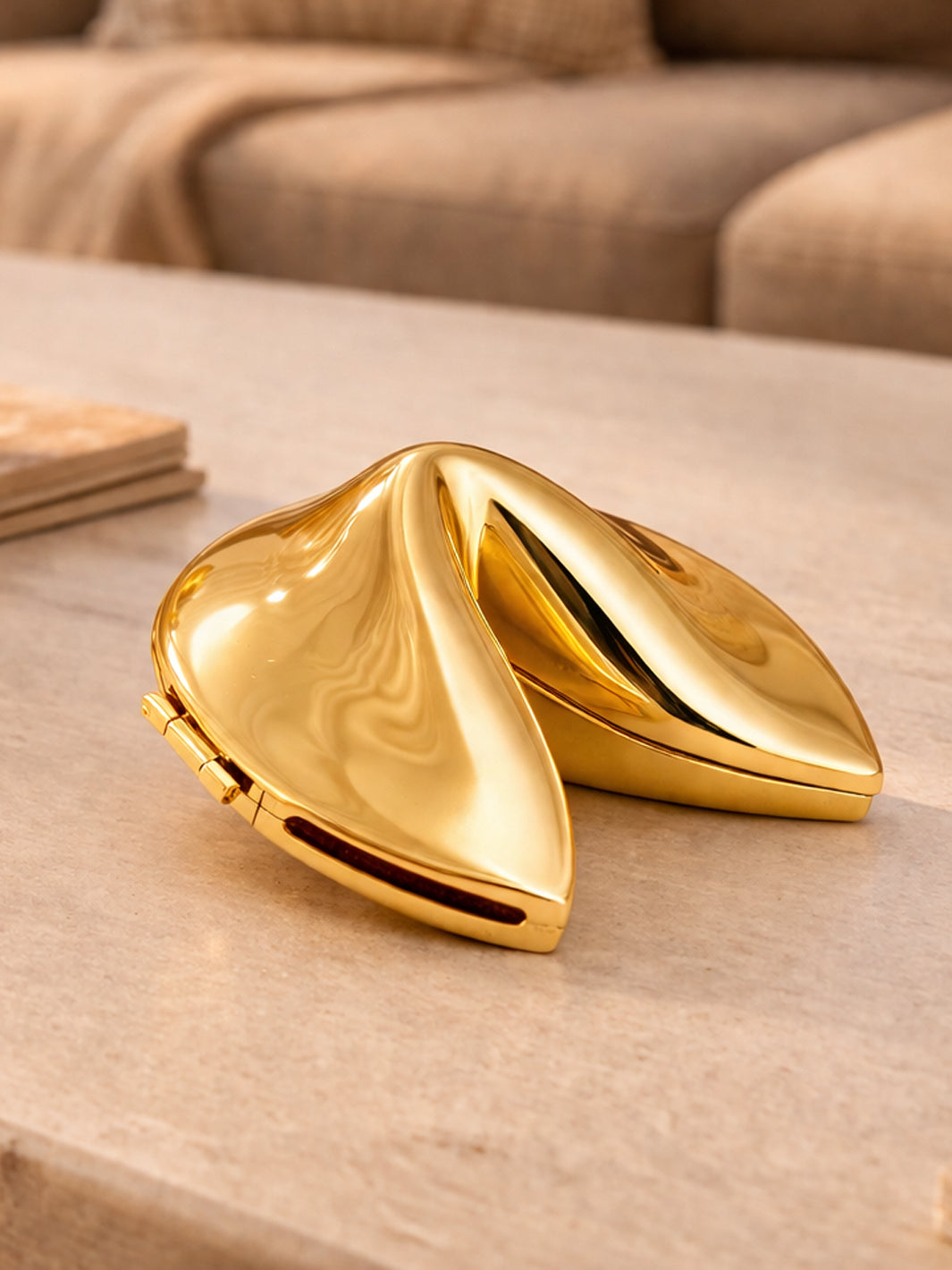 Gold-plated fortune cookie keepsake displayed on a coffee table with a polished high-shine finish | Twentyseven Toronto