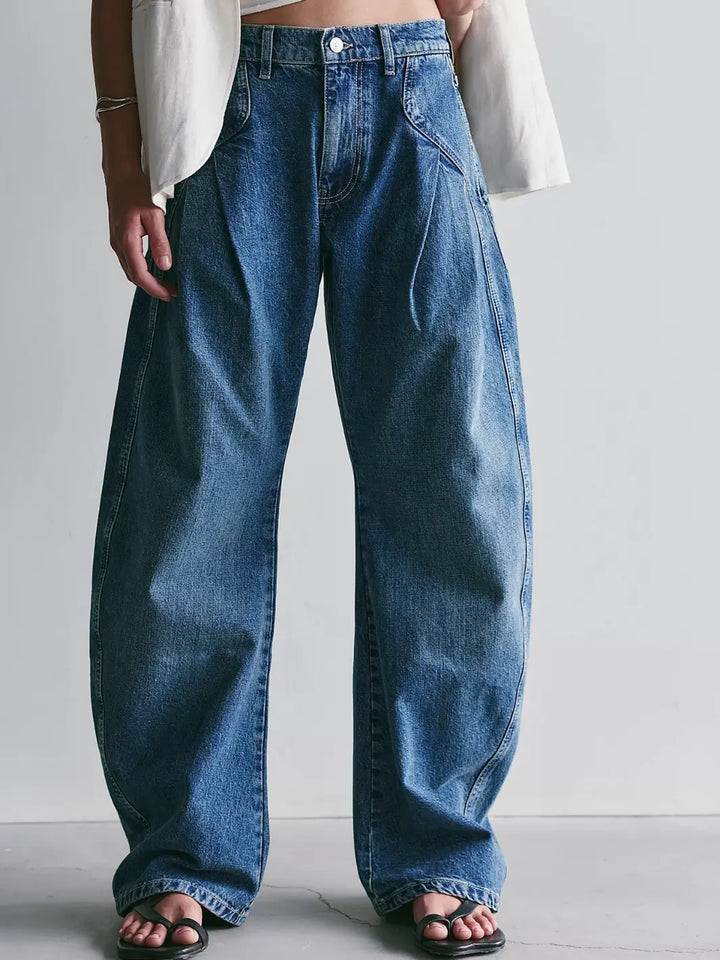 Front view of the Free People We the Free Golden Hour Trouser Jeans in Deacon Blue styled with black strap sandals against a light gray background | Twentyseven