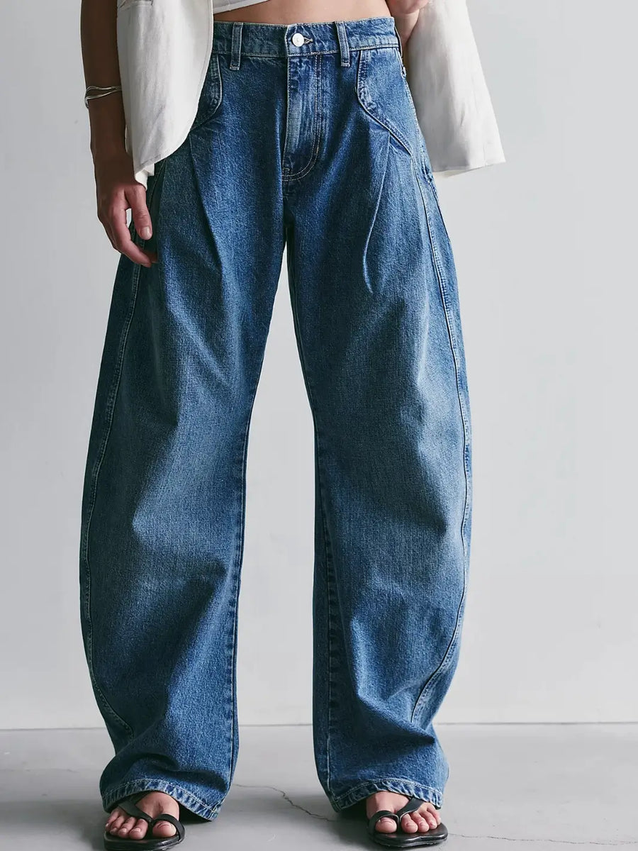 Front view of the Free People We the Free Golden Hour Trouser Jeans in Deacon Blue styled with black strap sandals against a light gray background | Twentyseven